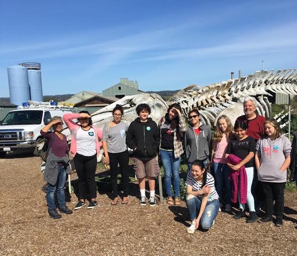 Pescadero Middle School students standing in front of a whale skeleton at the Seymour Center at UCSC.